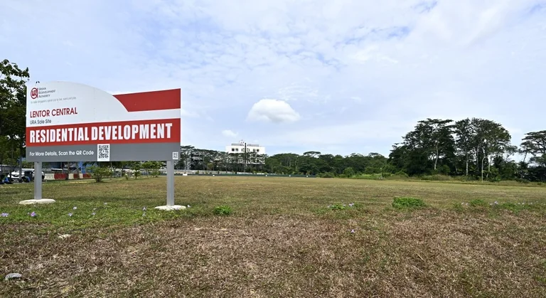 Photograph, illustrative only: the grassed Lentor Central land parcel in Lentor Hills with the URA sale-site board reading Residential Development, and a treeline beyond